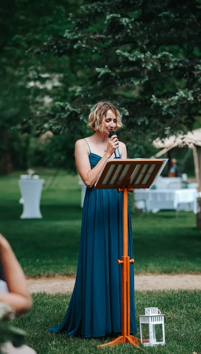 Amandine officiating a symbolic ceremony at the lectern in a garden in Alsace