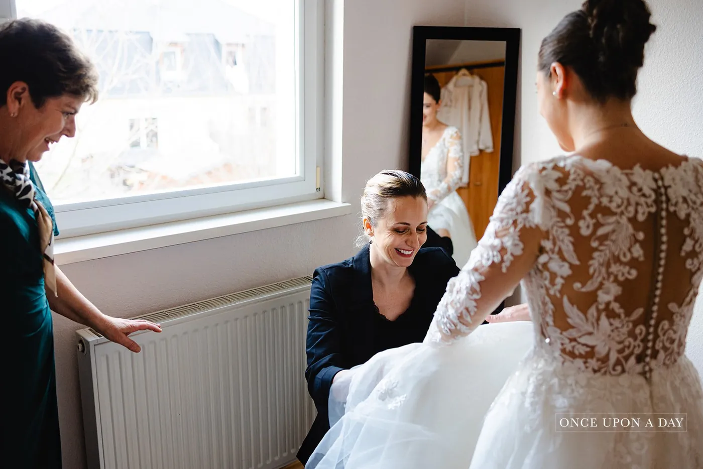 Amandine adjusting the bride's dress